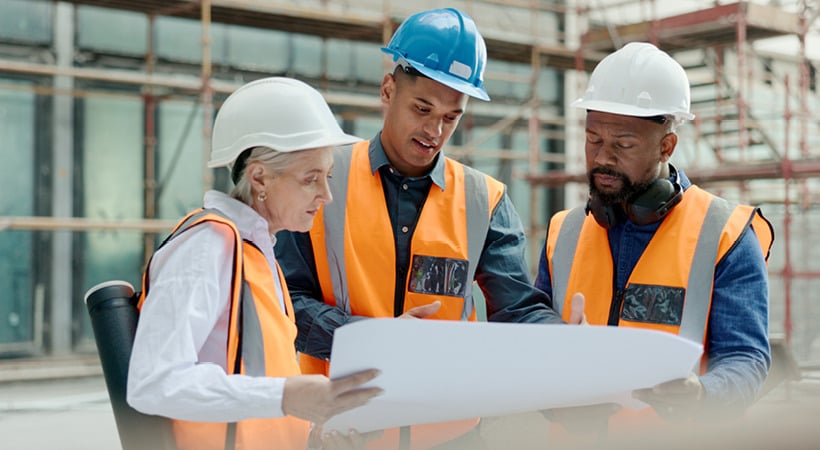 The aftermath of a flooded commercial building, gutted down to the concrete, load-bearing walls, with debris littering the floor.