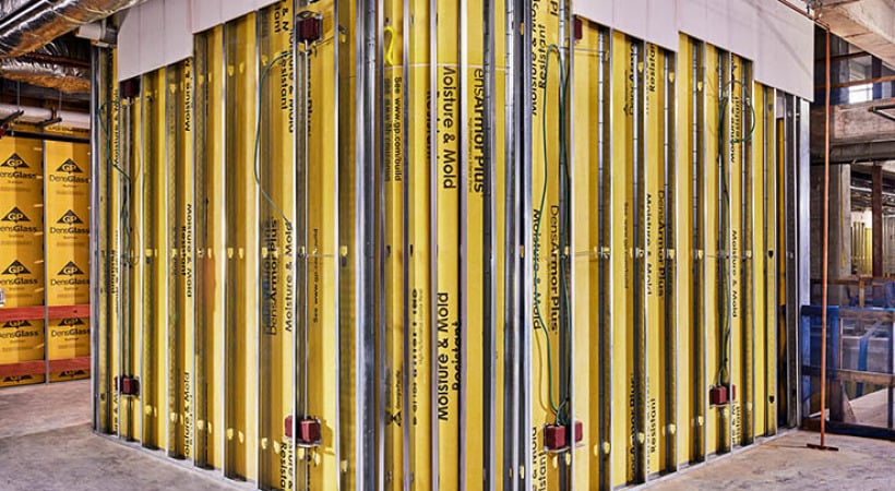 Gold DensArmor Plus® Interior Panels line the walls of a partially completed interior room.